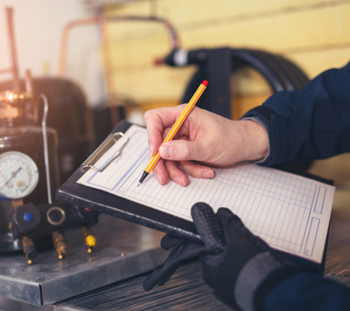 Man going over a hvac maintenance checklist on a clipboard