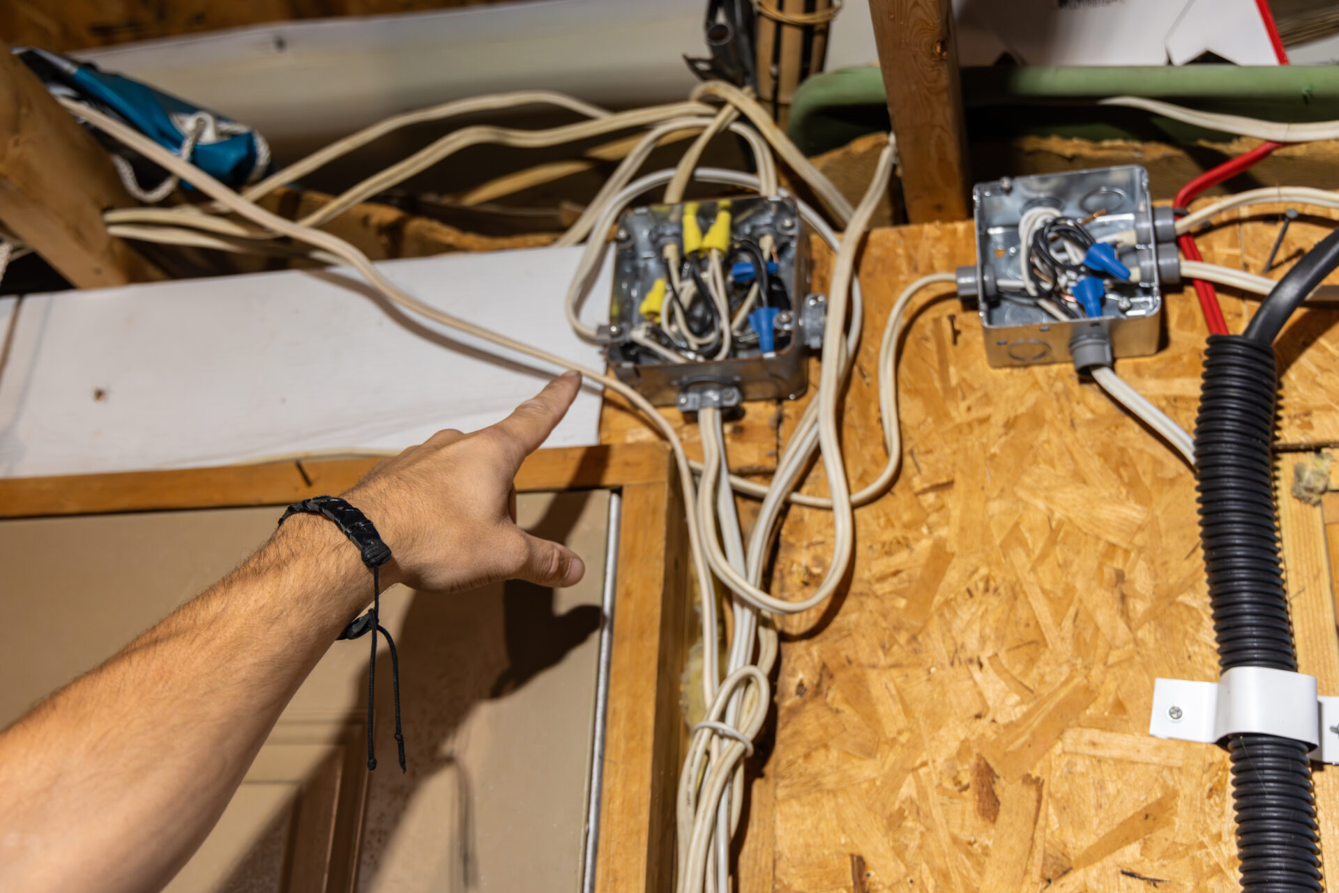 Electrician inspecting electrical wiring installation in attic Electrician inspecting electrical wiring installation in attic