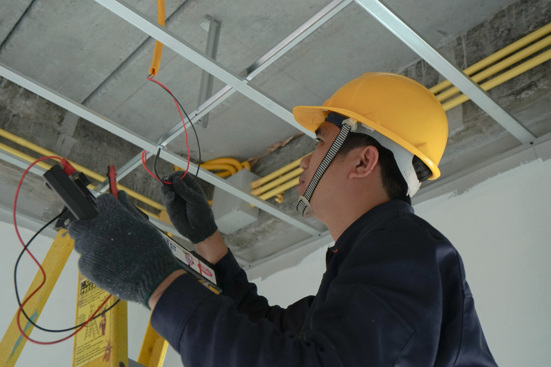 Electrician checking the current for the installation of electrical system in the house. Concept of electrical installation in the house and safety in construction. Electrician checking the current for the installation of electrical system in the house. Concept of electrical installation in the house and safety in construction.