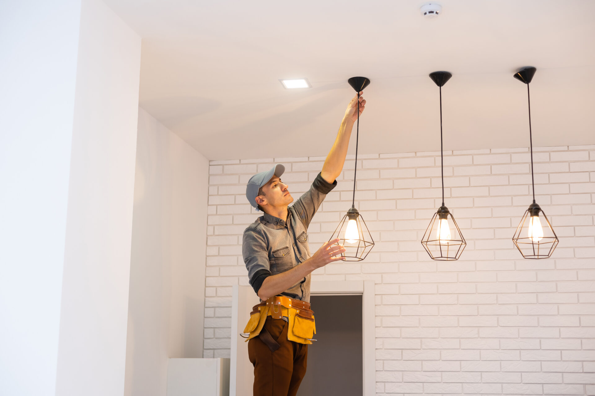 Electrician worker installation electric lamps light inside apartment. Construction decoration concept. Electrician installing lights